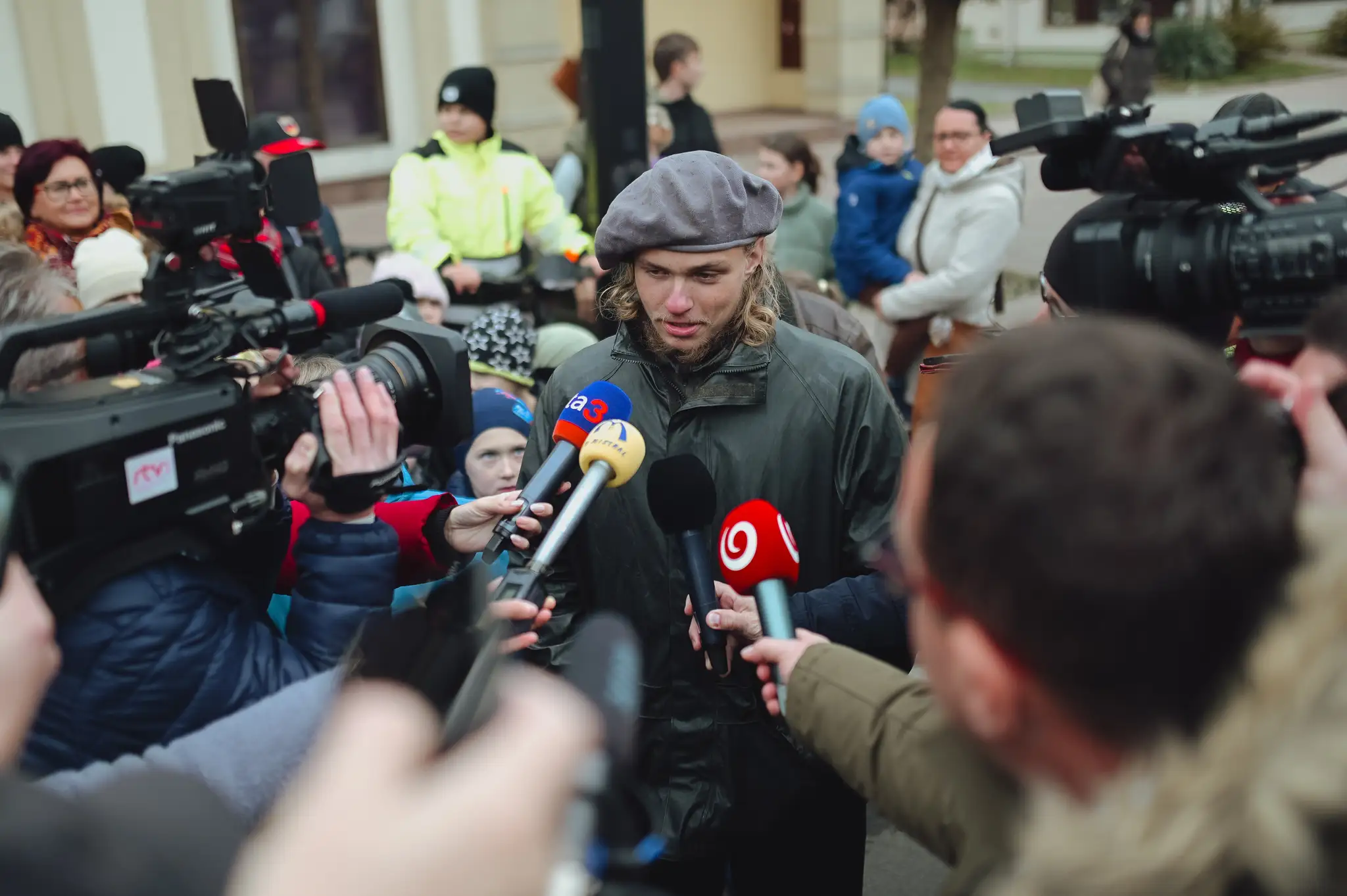 Ján v obklopení mikrofónov po návrate domov