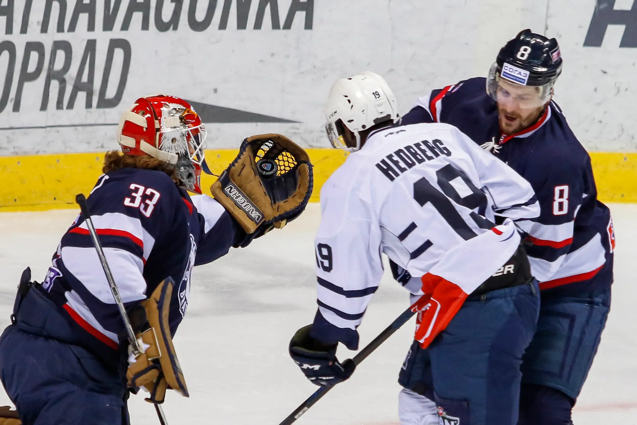 Zľava Barry Brust (Slovan), Edwin Hedberg (Medveščak Zahreb) a Michal Sersen (Slovan) vo vzájomnom zápase KHL.
