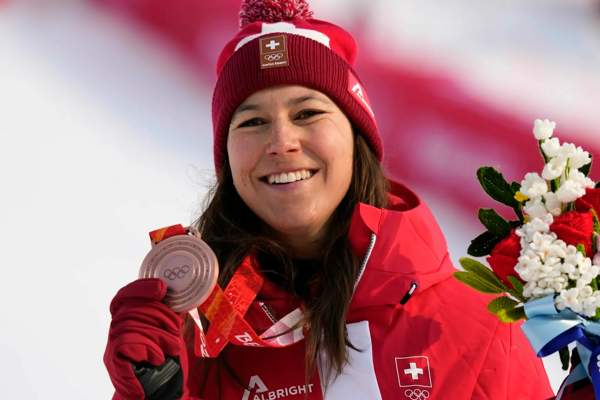 Švajčiarska lyžiarka Wendy Holdenerová pózuje s bronzovou medailou v slalome na ZOH 2022.