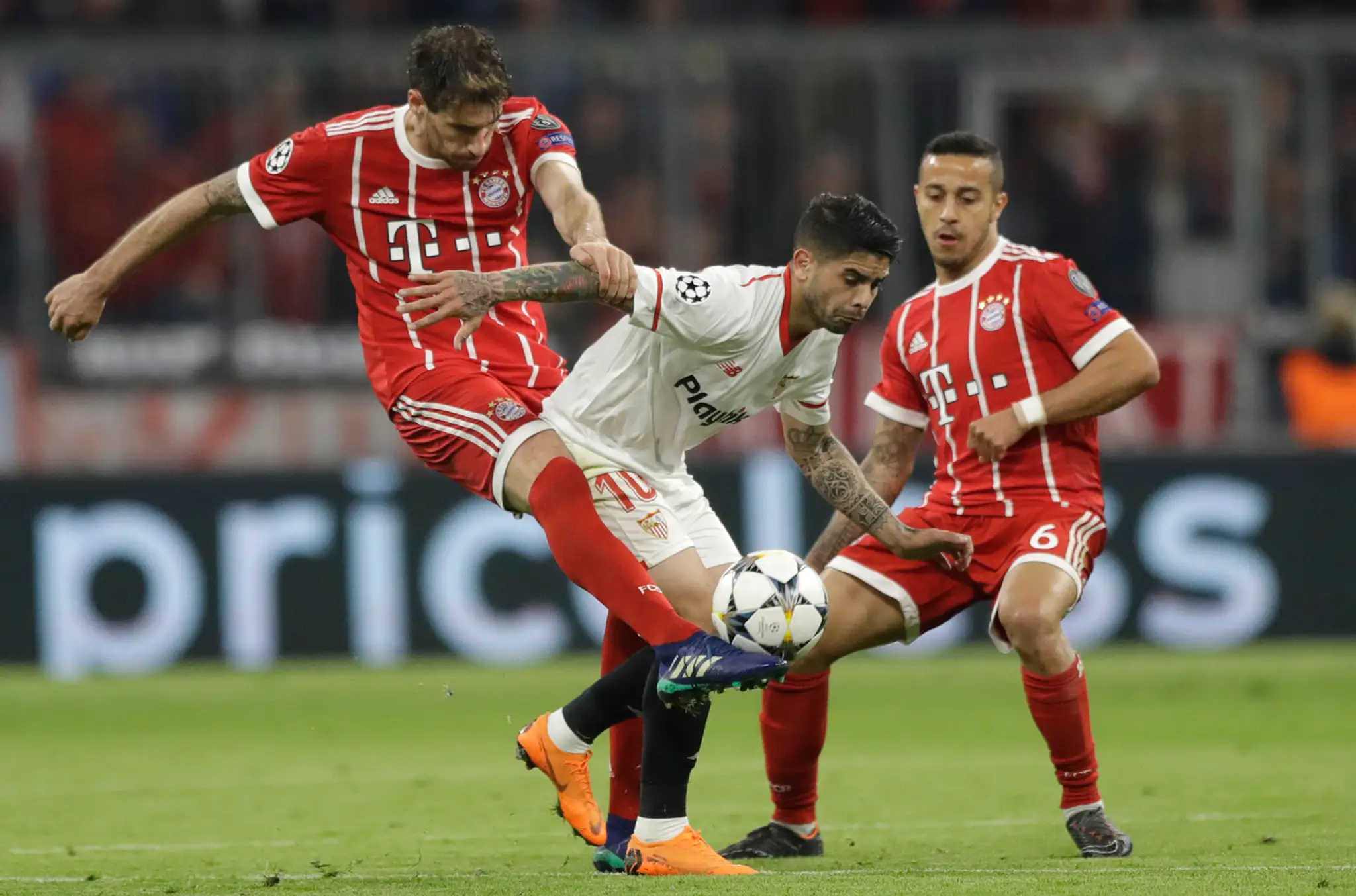 Éver Banega (v strede) zo Seville v obkľúčení Javiho Martineza (vľavo) a Rafinhu z Bayernu v odvete štvrťfinále LM.