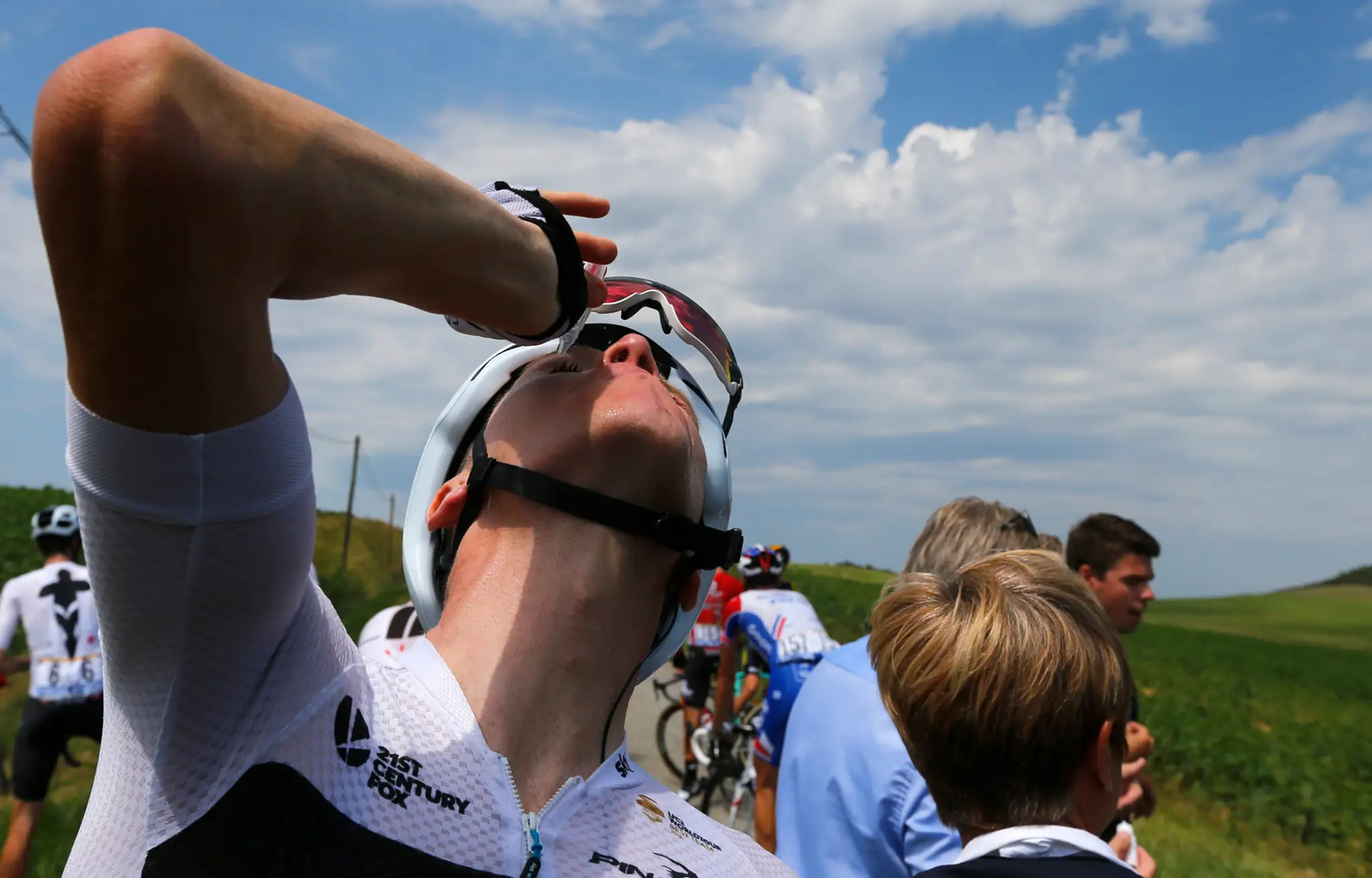Cyklista Chris Froome si dáva kvapky do očí po tom, čo sa mu do očí dostal slzný plyn.
