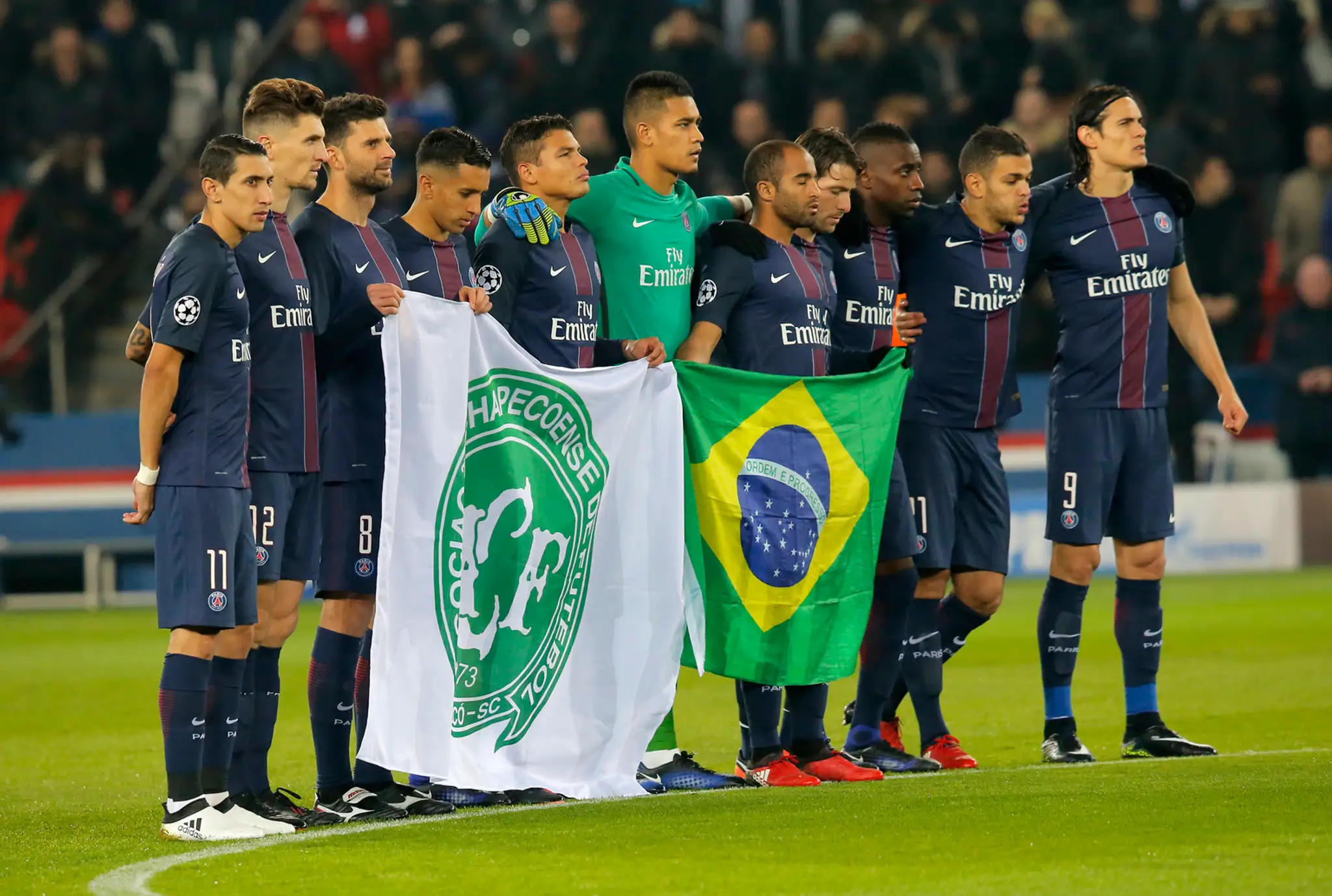 Hráči PSG držia brazílsku vlajku a zástavu klubu Chapecoense na znak smútku pred duelom LM proti Ludogorcu.