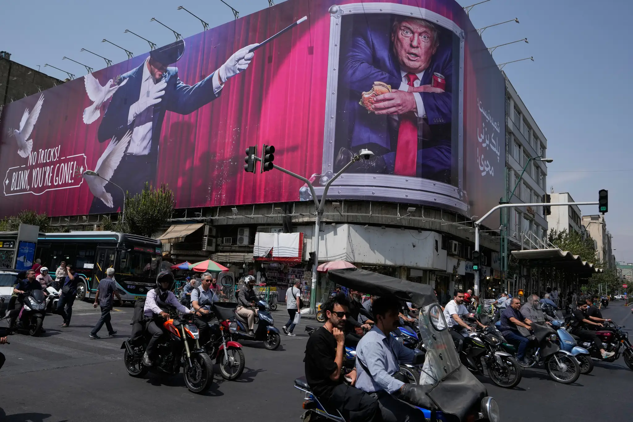 Motocyklisti prechádzajú v centre Teheránu v Iráne okolo billboardu, na ktorom je vyobrazený americký prezident Donald Trump.