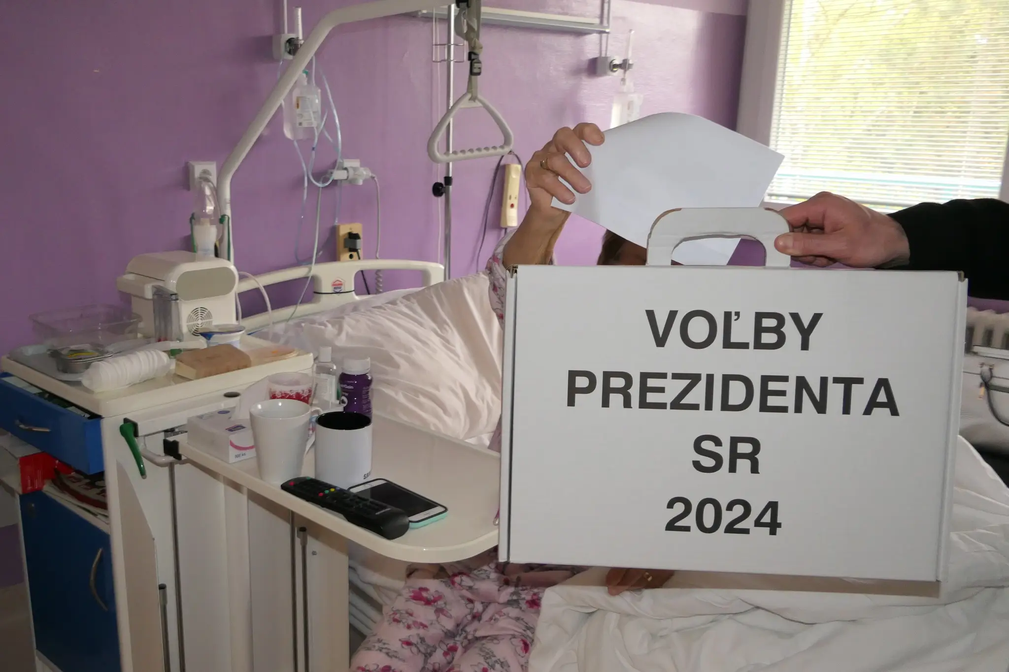 Pacientka vhadzuje obálku do prenosnej volebnej schránky v druhom kole prezidentských volieb vo Fakultnej nemocnici s poliklinikou v Žiline
