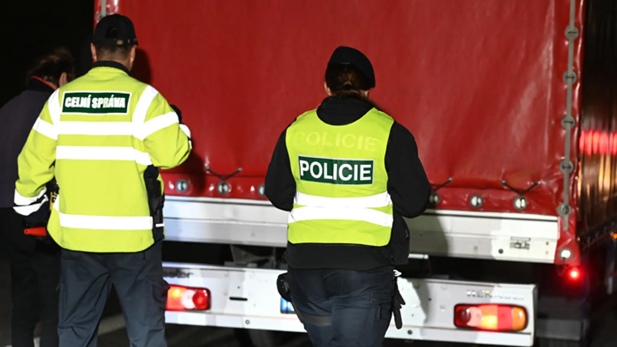 Colník počas policajnej kontroly kamióna na hraniciach.