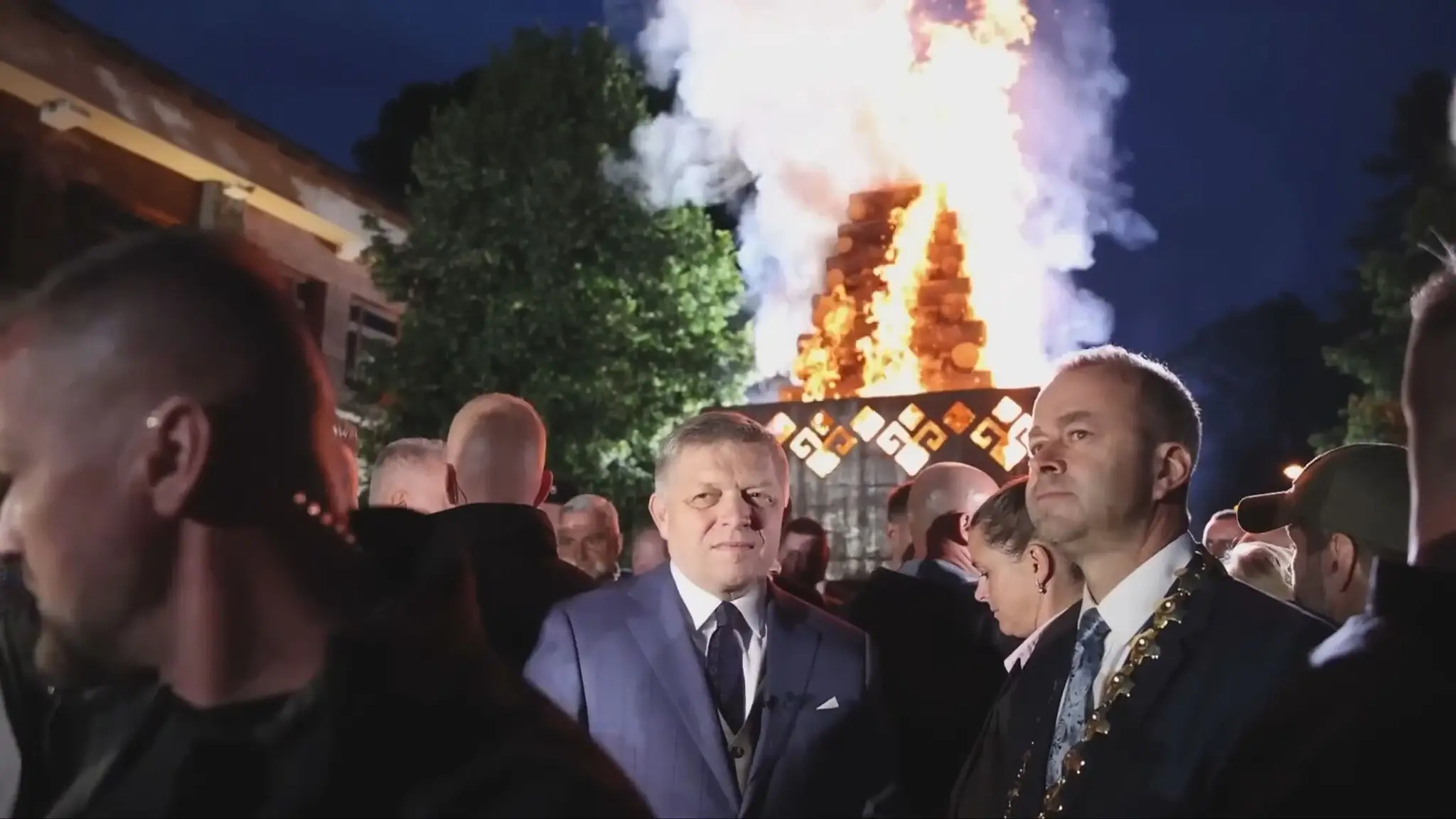 Robert Fico a Ján Podmanický s vatrou v pozadí.