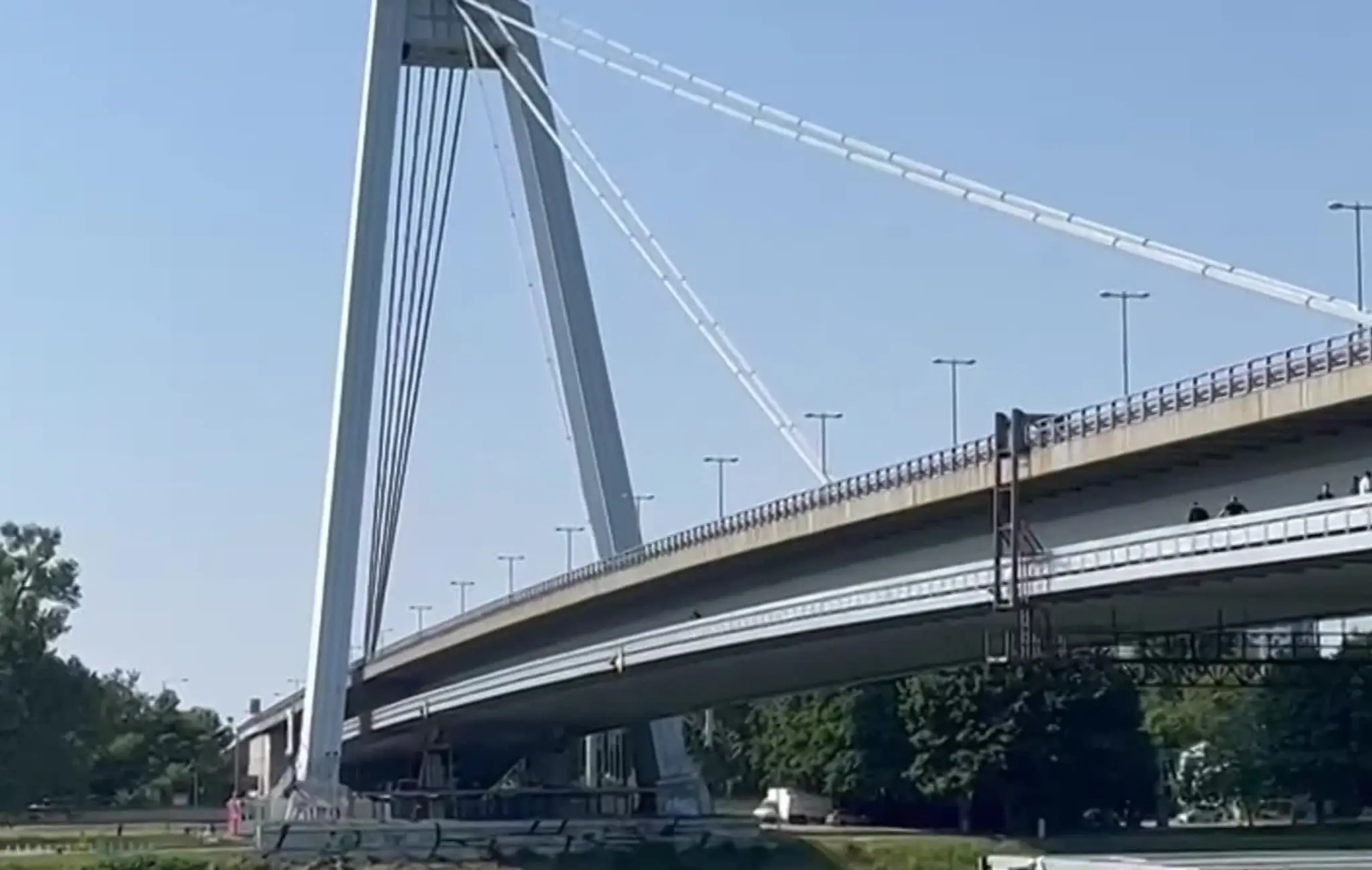 Muž sedí na zábradlí Mosta SNP