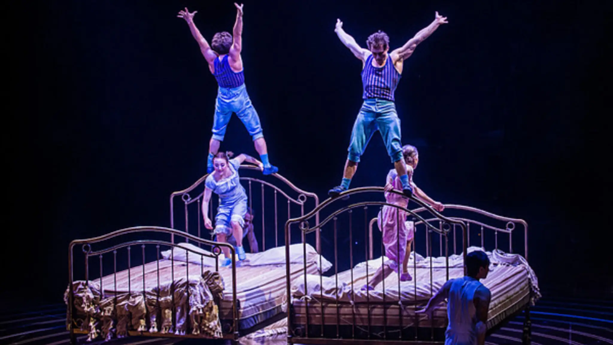 Artisti Cirque Du Soleil na trampolínových posteliach.