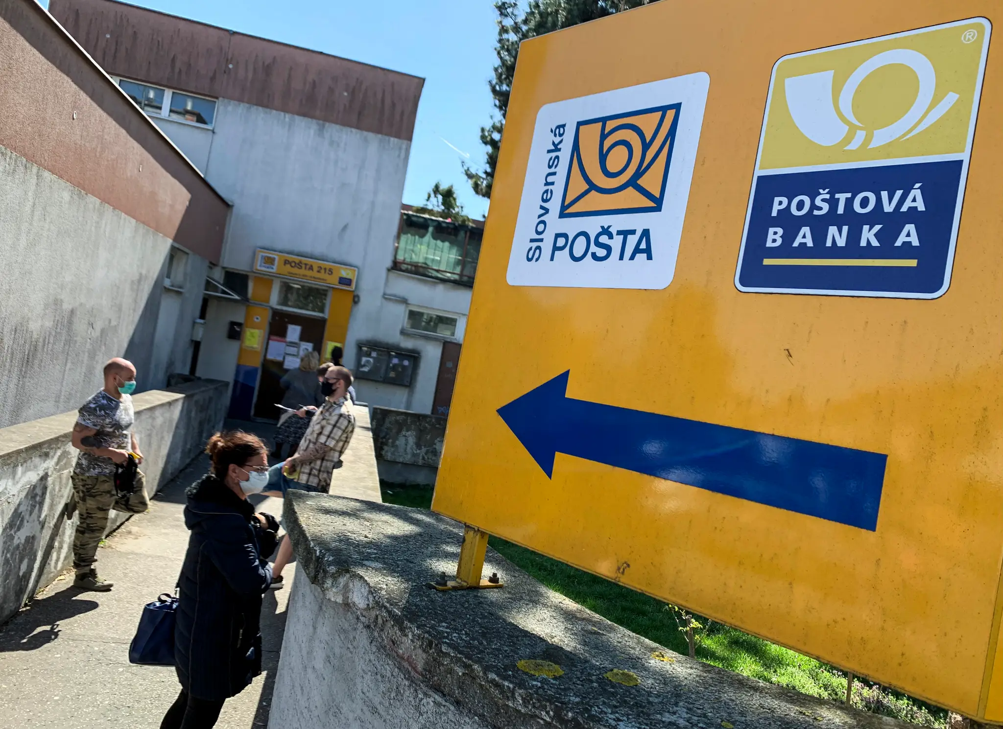 Ľudia pred pobočkou Slovenskej pošty
