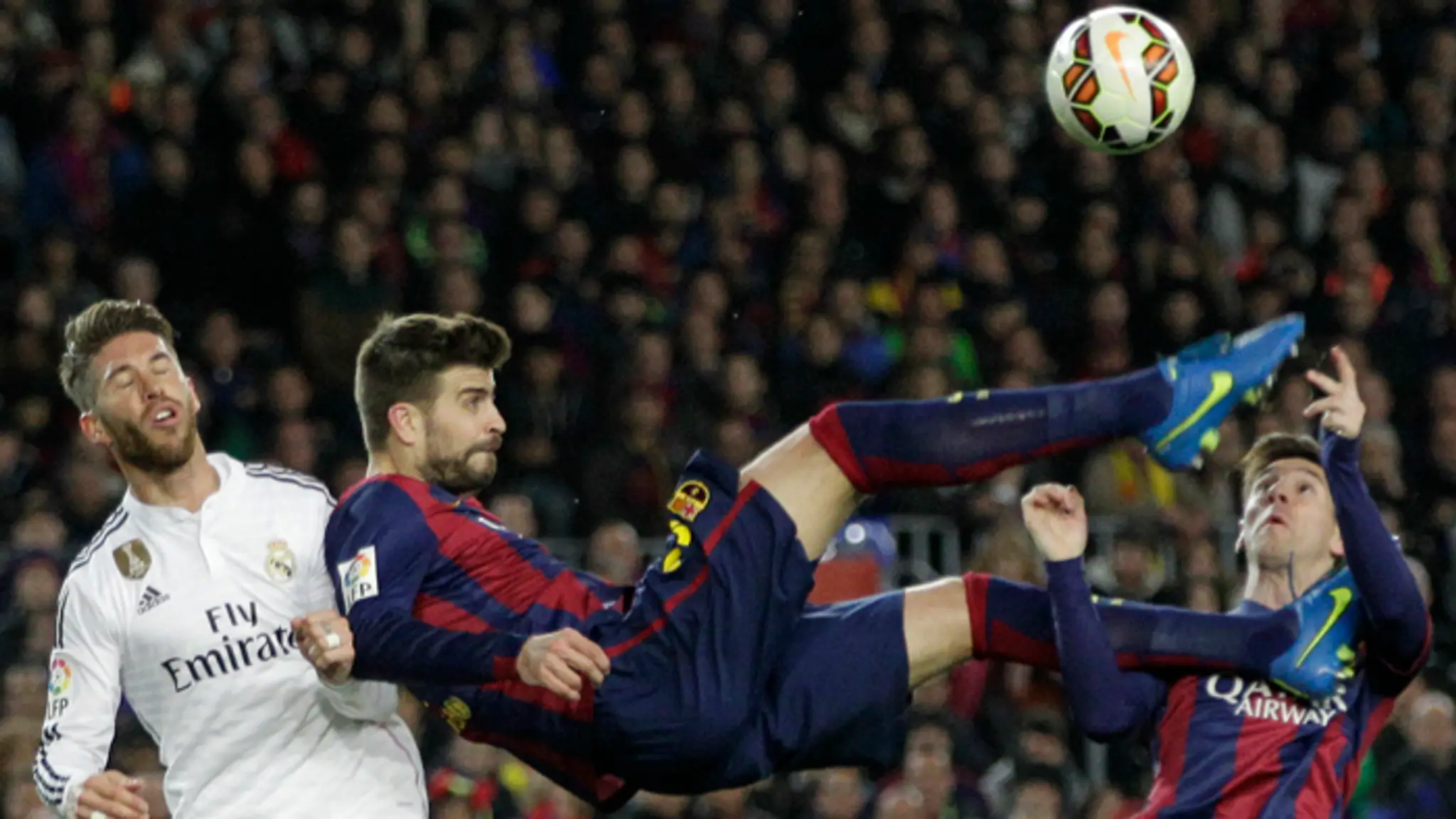Gerard Pique a Lionel Messi (Barcelon) v akcii so Sergiom Ramosom (Real Madrid) počas El Clásico.