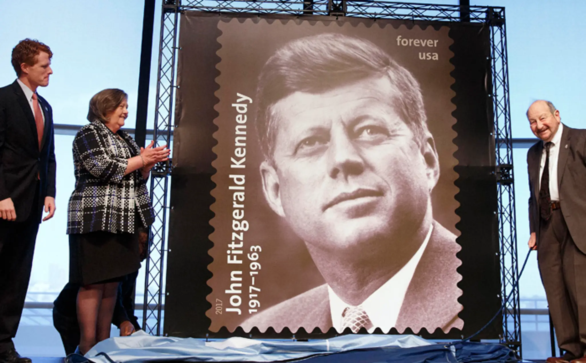 Kongresman Joseph P. Kennedy III. s novou známkou JFK, vpravo fotograf Ted Spiegel, ktorú snímku urobil v roku 1959.