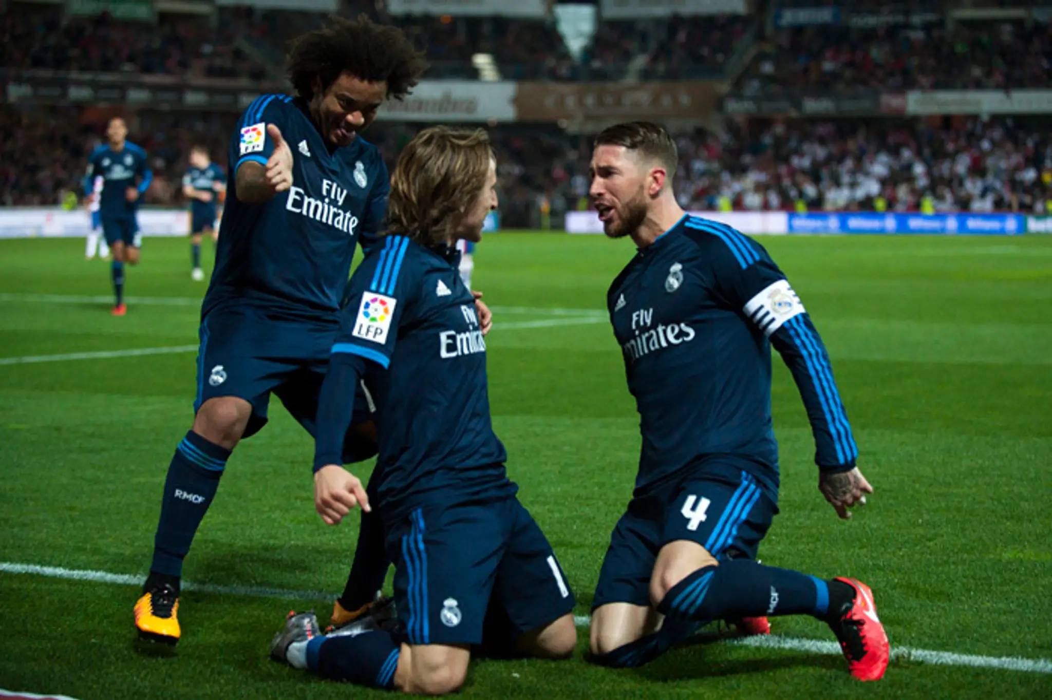 V strede hráč Realu Madrid Luka Modrič sa raduje so spoluhráčmi Marcelom (vľavo) a Sergiom Ramosom.