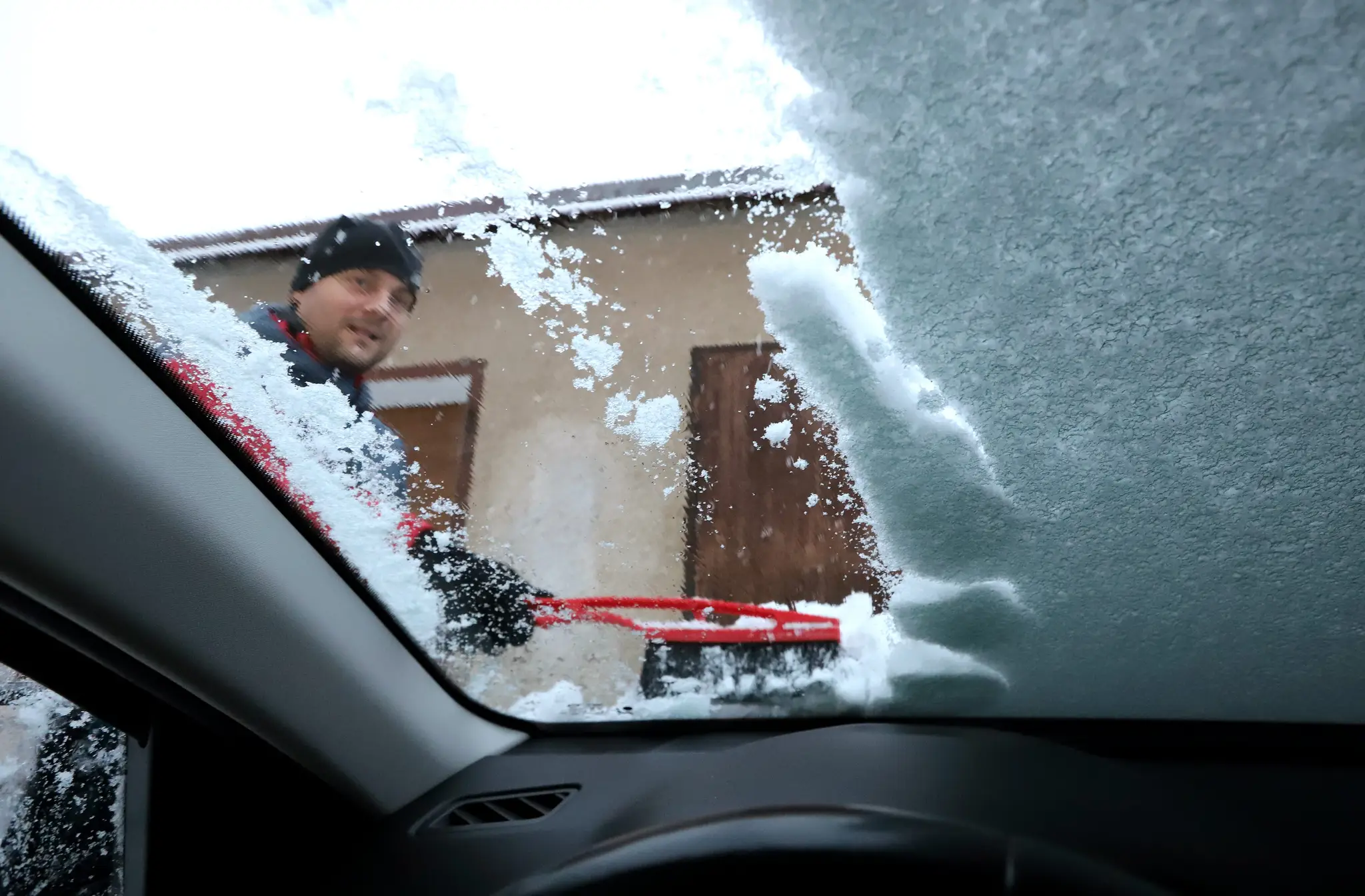 Na snímke vodič odhrabáva sneh z osobného auta počas ranného sneženia vo Zvolene.