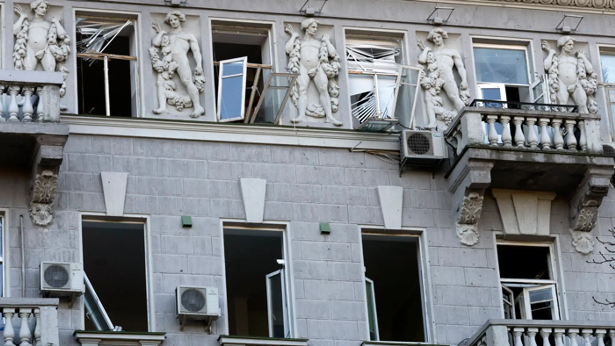 Rozbité sklá na oknách historickej budovy po ruskom raketovom útoku v Kyjeve.