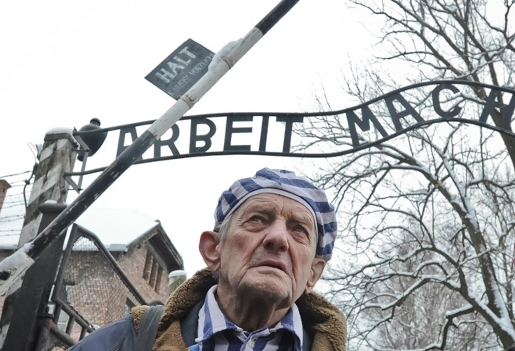 Bývalý väzeň koncentračného tábora Auschwitz pri Osvienčime Igor Malitský z Ukrajiny pri vstupnej bráne do tábora smrti.