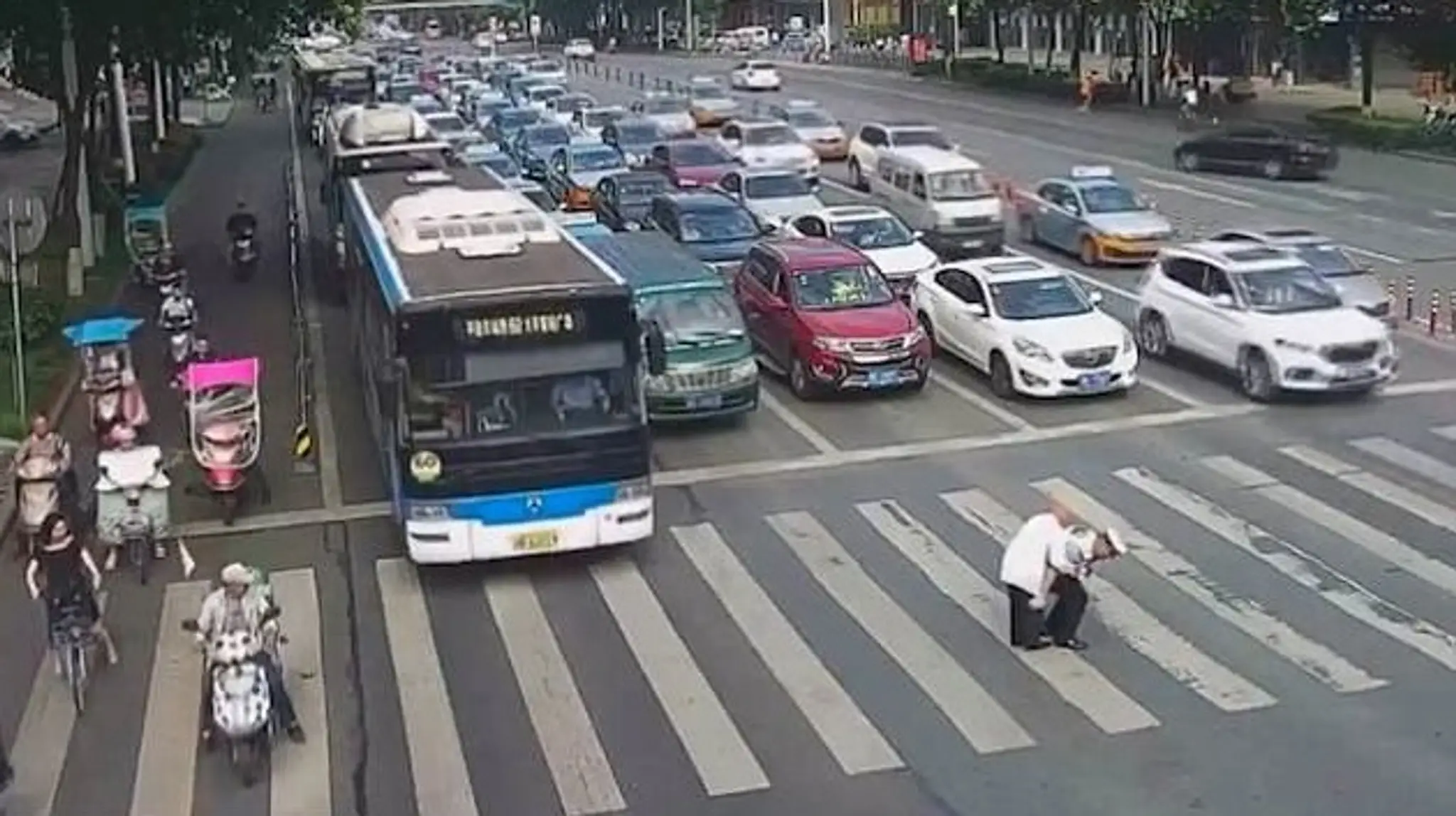 Čínsky policajt preniesol starčeka ceuz cestu na chrbte