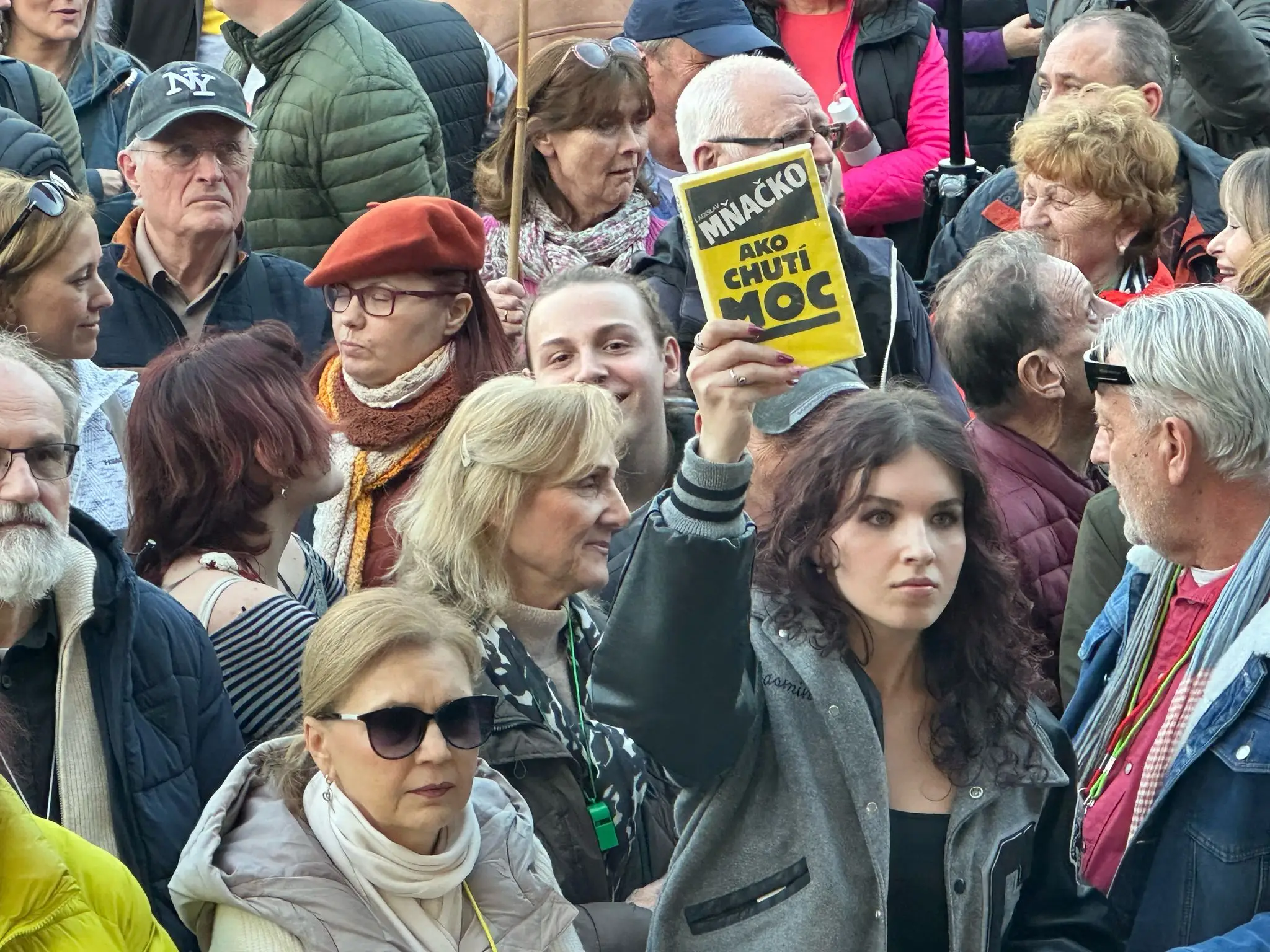 Protestujúca drží v ruke knihu Ako chutí moc