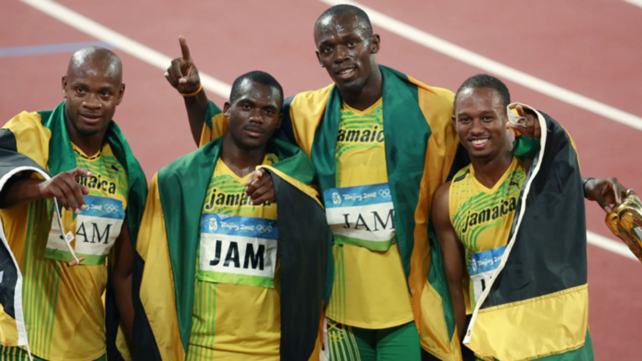 Jamajskí bežci zľava Asafa Powell, Nesta Carter, Usain Bolt a Michael Frater po víťaztve v štafete na OH v Pekingu.