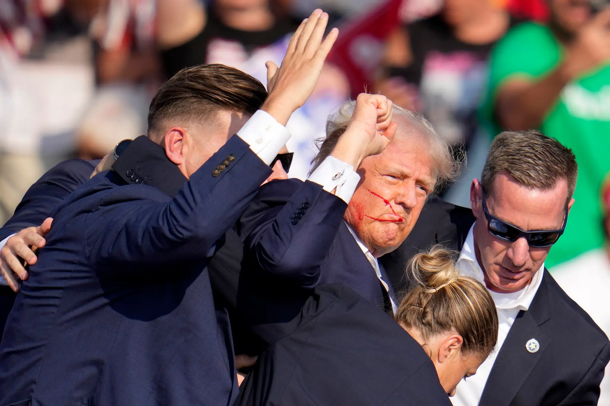 Donaldovi Trumpovi pomáhajú z pódia agenti tajnej služby.