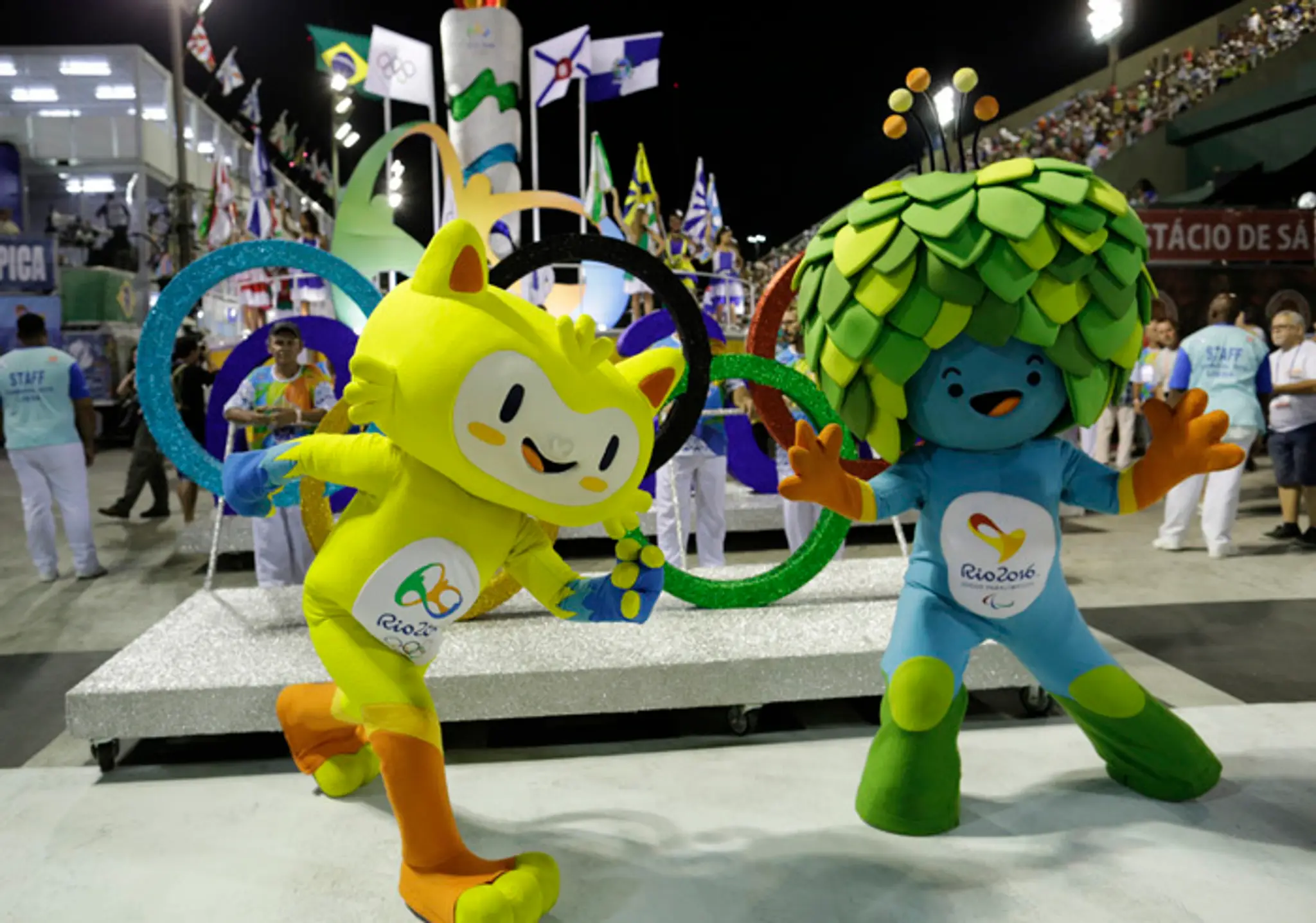 Maskoti OH - žltá mačka (vľavo), symbol paralympiády - modrá figúrka so zelenými vlasmi v tvare listov.
