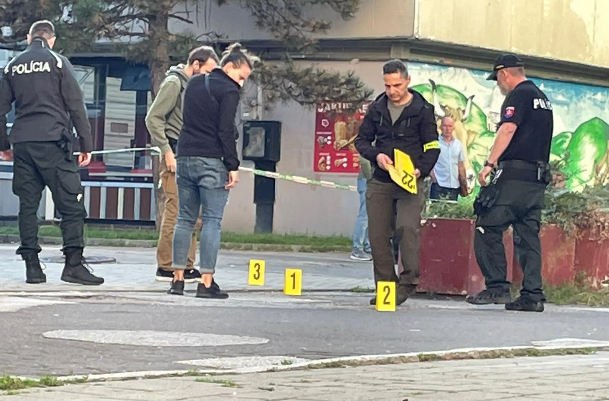Policajti označujú miesto po streľbe.