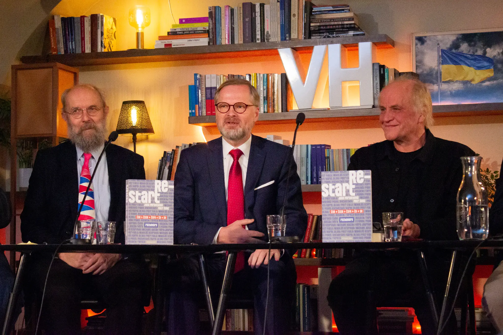 Na snímke zľava jazykovedec Karel Oliva, český premiér Petr Fiala a hudobník a bývalý politik Michael Kocáb na krste knihy Restart v Knižnici Václava Havla.