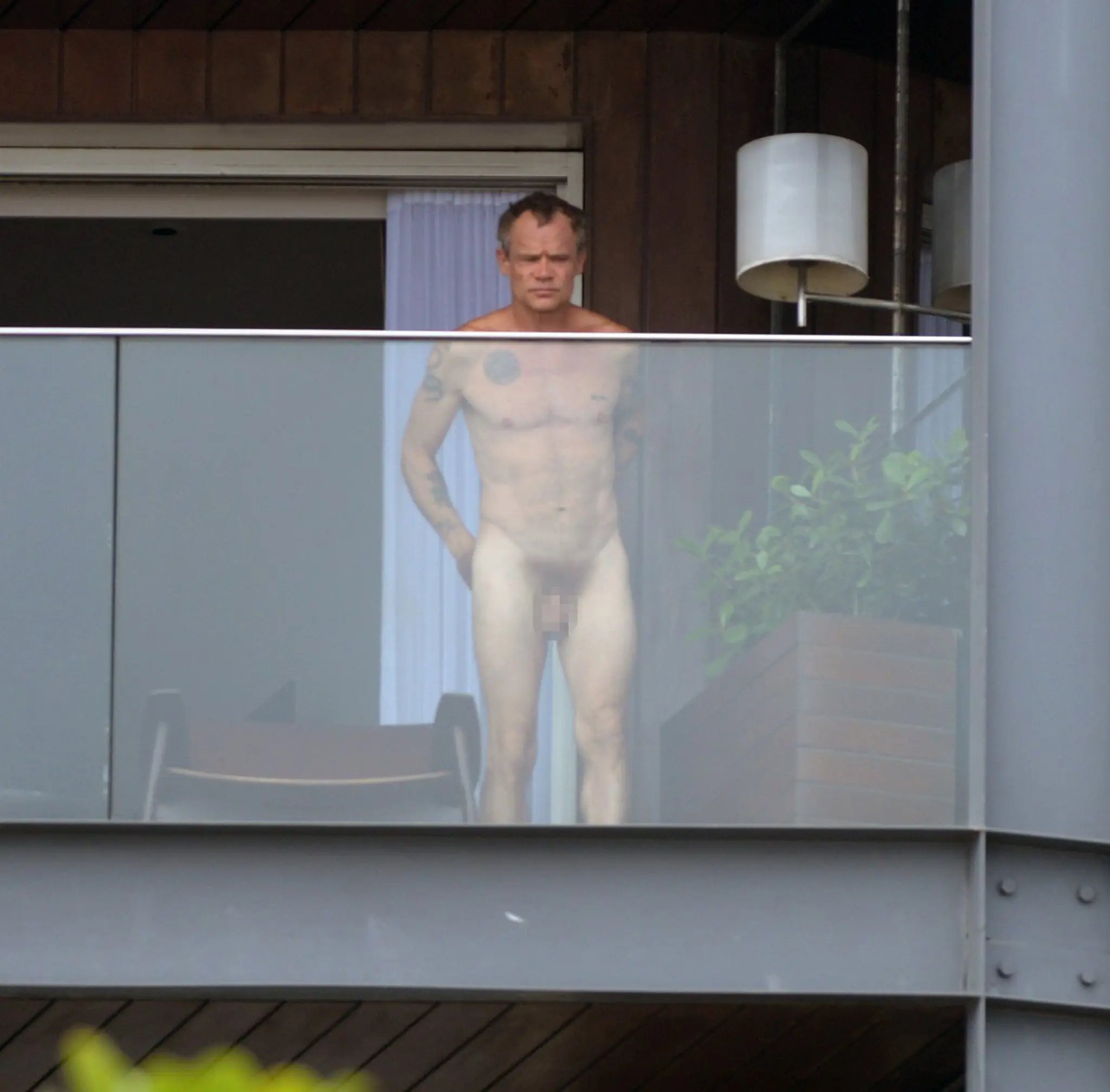Úplne nahý basgitarista na balkóne. Netrápilo ho, že cez sklo je všetko vidieť