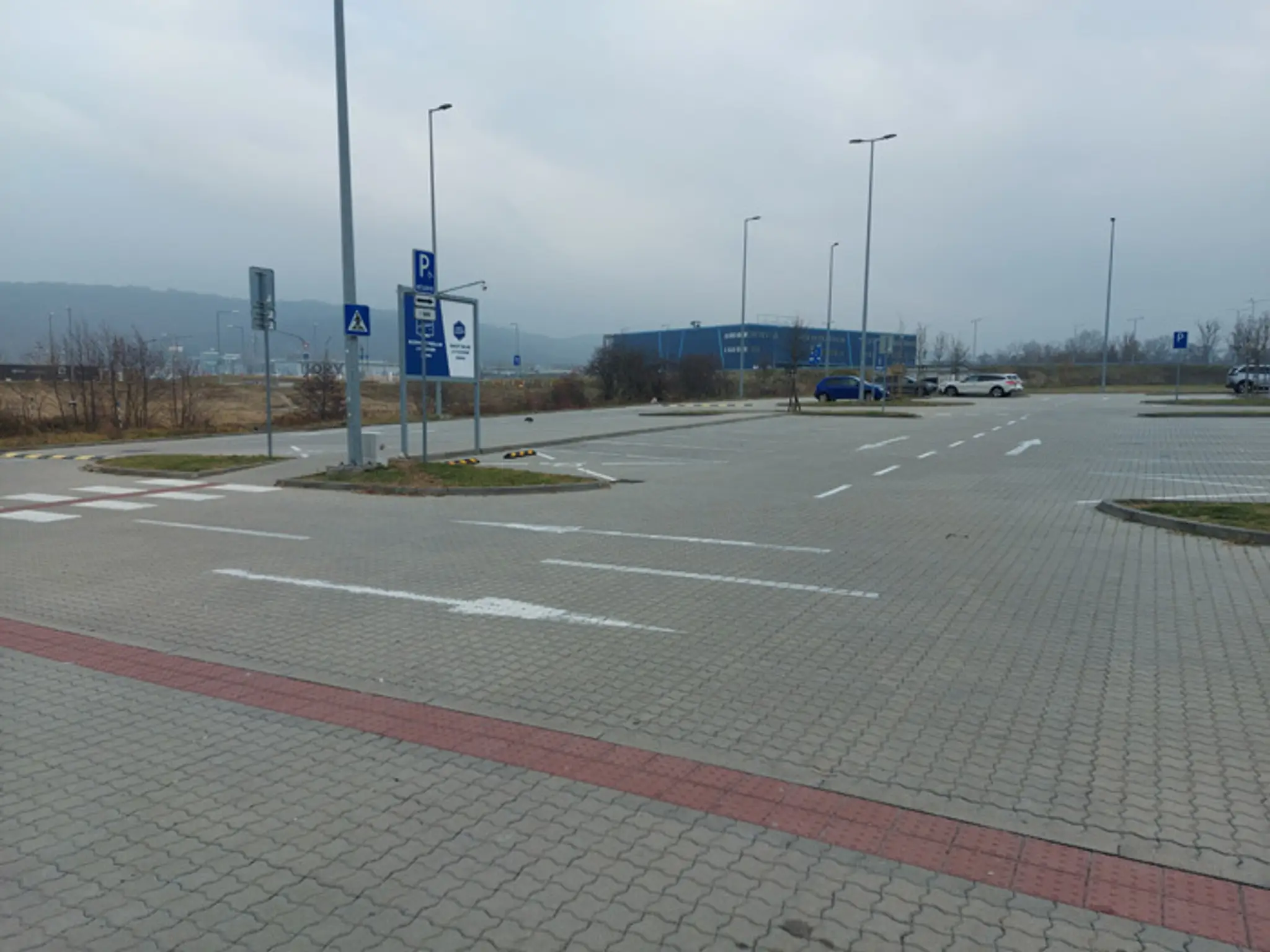 Prázdne parkovisko pred obchodom so športovým tovarom.