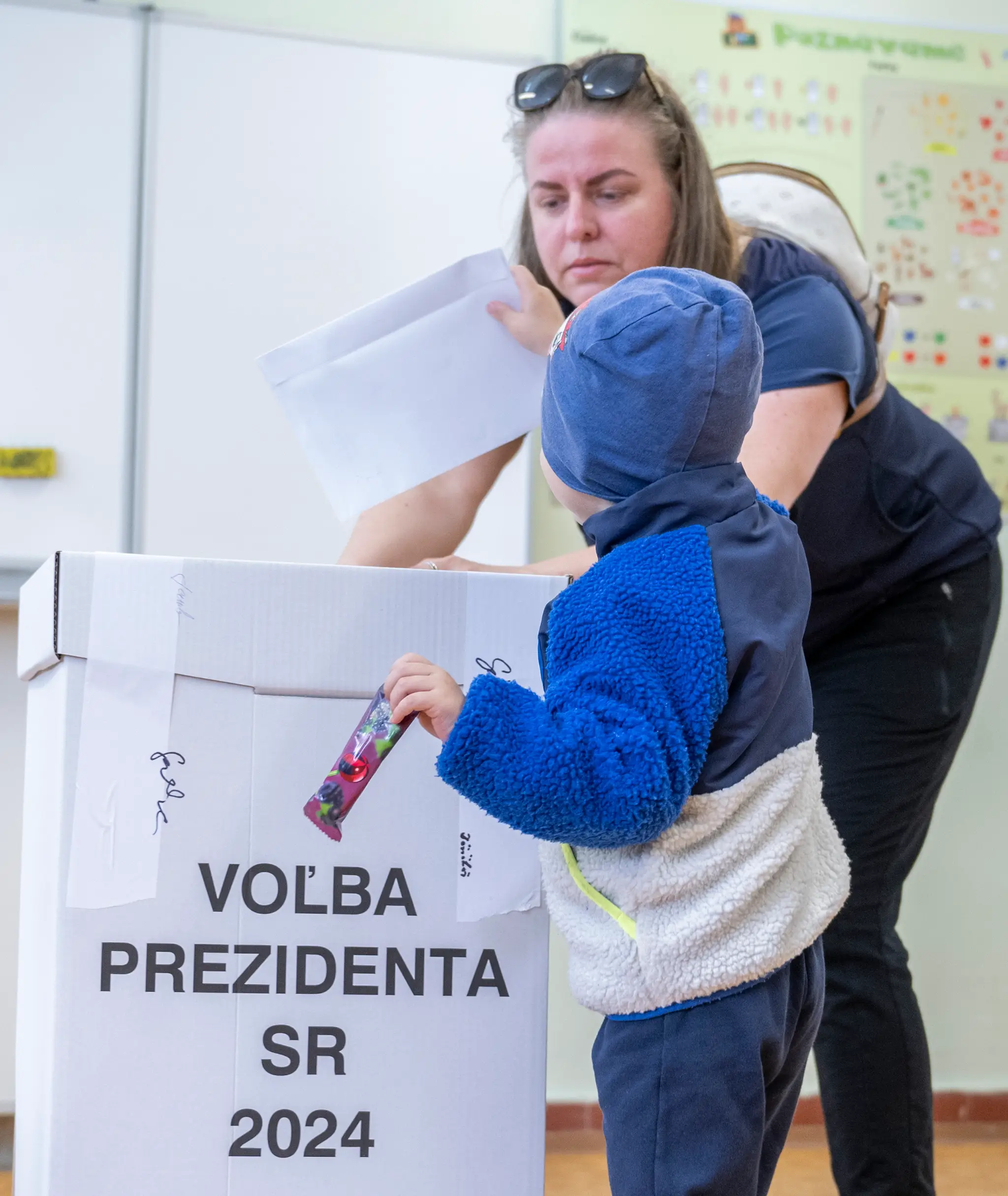 Chlapec vhadzuje obálku s hlasovacím lístkom do volebnej schránky v Senci.