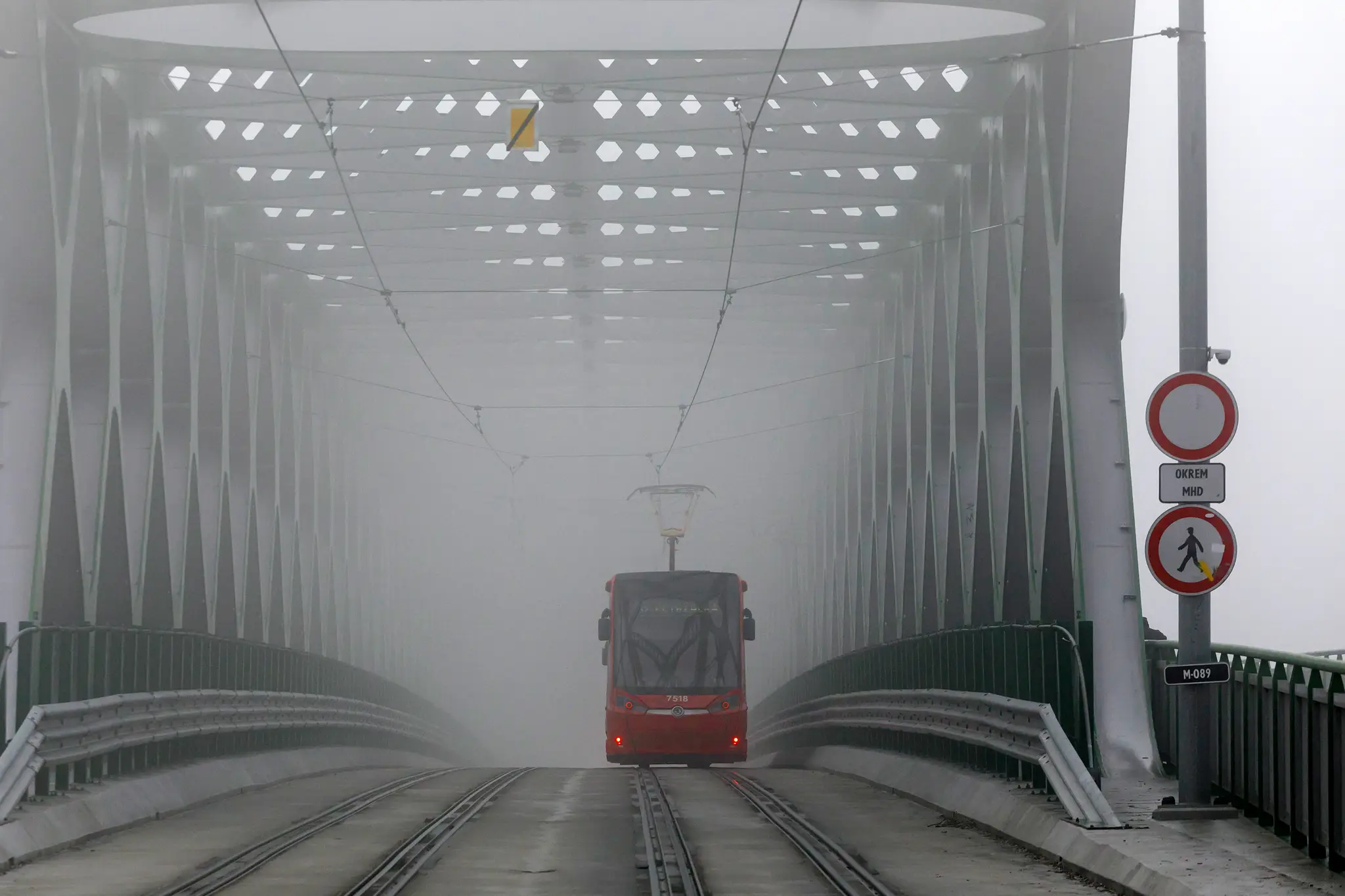 Na snímke električka jazdí po Starom moste počas hmlistého počasia v Bratislave.