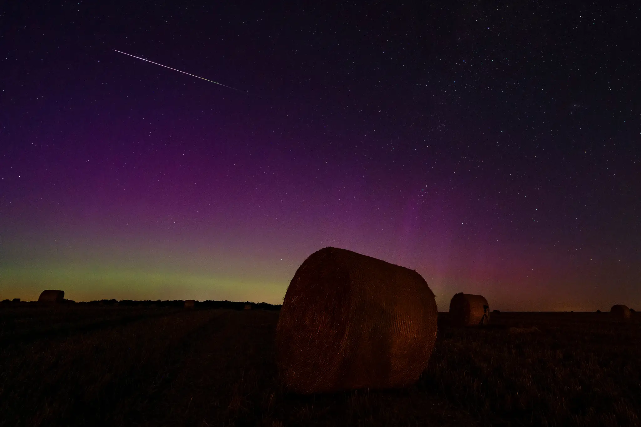 Polárna žiara osvetľuje nočnú oblohu s meteorickým rojom Perzeíd v Nemecku.