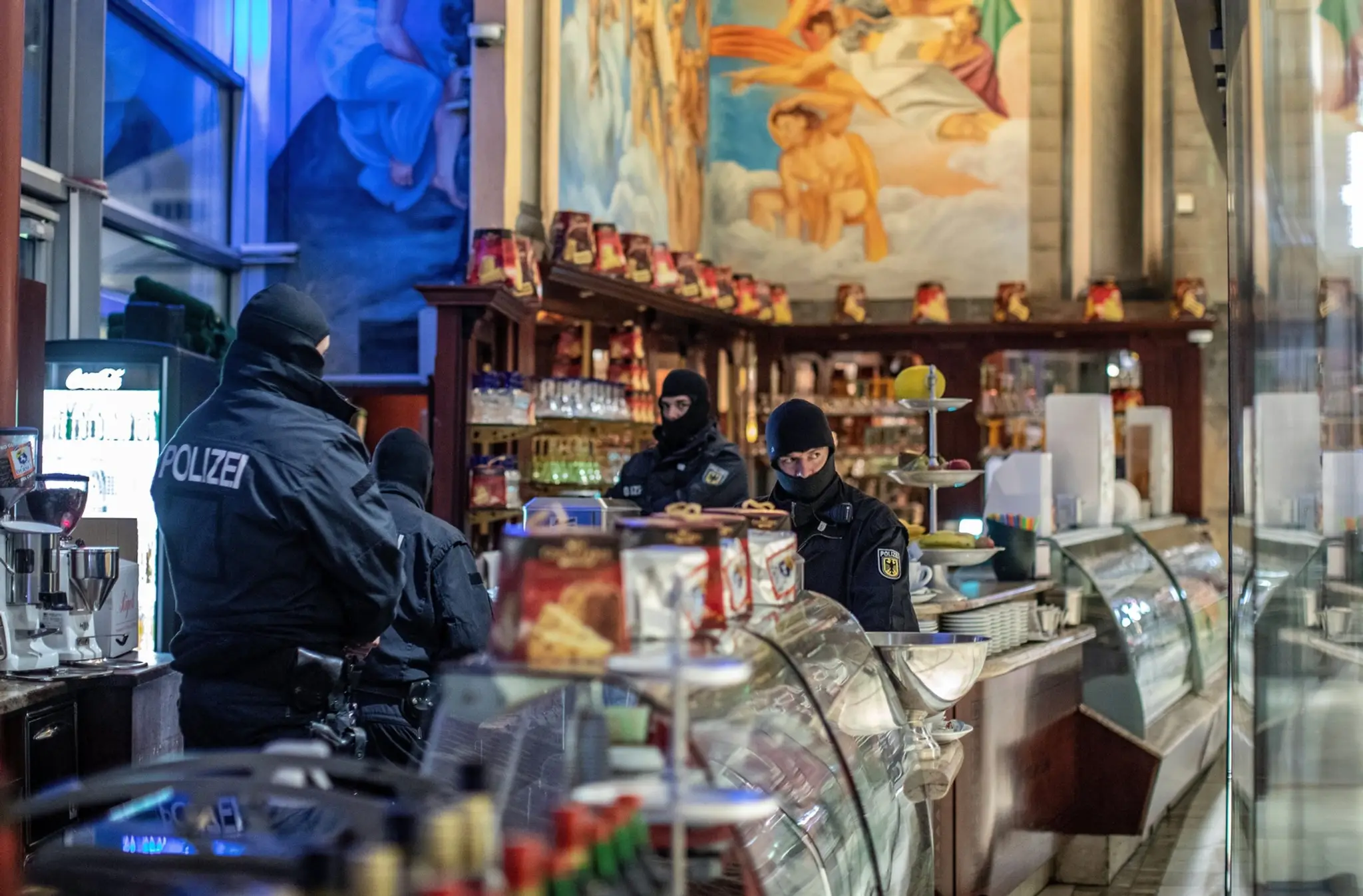 Nemeckí policajti počas razie proti členom 'Ndranghety v kaviarni Duisburgu.