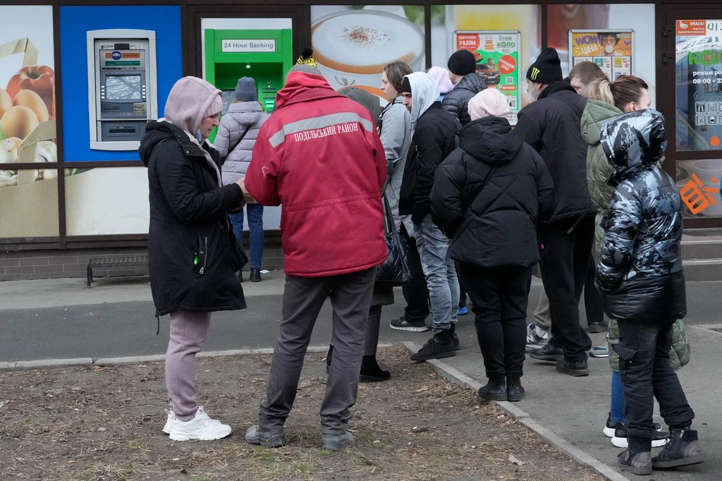Ľudia čakajú pred bankomatom, aby si vybrali peniaze v Kyjeve