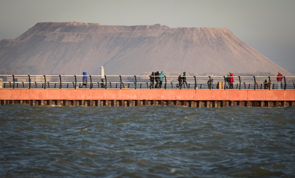 Na snímke z 19. februára 2022 sa miesti obyvatelia prechádzajú pozdĺž plošiny pri Azovskom mori v Mariupole.