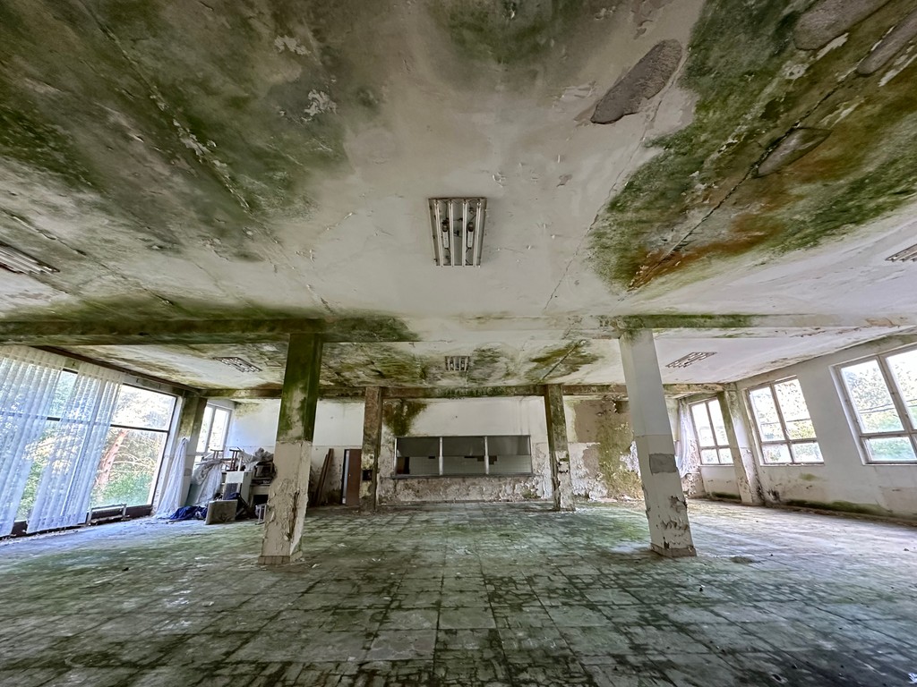 Zdevastovaná bývalá jedáleň v opustenom internáte.