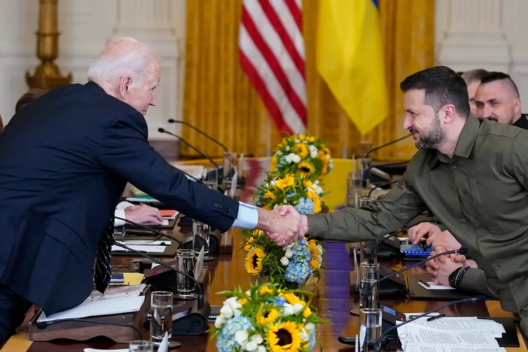  Americký prezident Joe Biden a ukrajinský prezident Volodymyr Zelenskyj si podávajú ruky.
