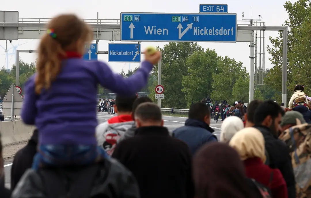Migranti kráčajú po diaľnici A4 smerom do Viedne po prekročení hranice medzi Maďarskom a Rakúskom, pri rakúskom Nickelsdorfe.