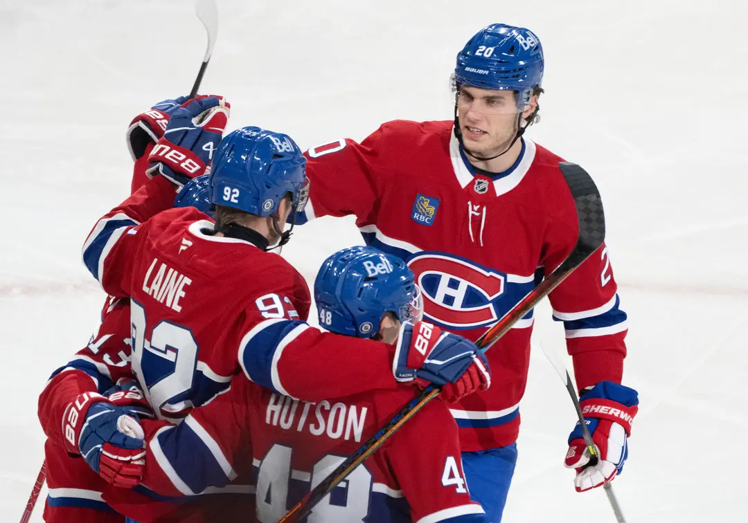 Slovenský hokejista Montrealu Canadiens Juraj Slafkovský (20) sa teší so spoluhráčmi z gólu, ktorý strelil Patril Laine.