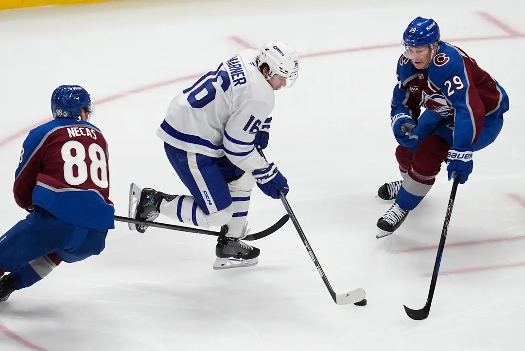 Na snímke hokejista Toronta Mitch Marner (uprostred), hráči Colorada Martin Nečas (vľavo) a Nathan MacKinnon (vpravo).