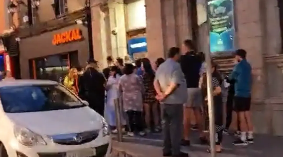 Dav ľudí pred jedným z bankomatov.