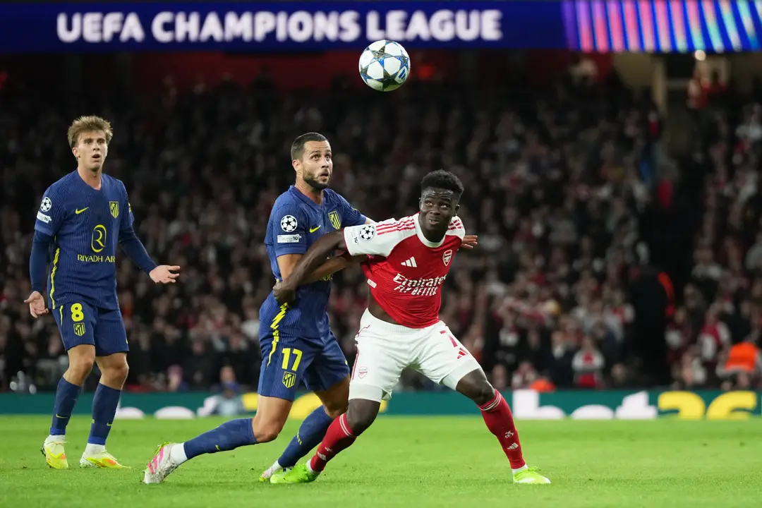 Slovenský futbalista v drese Atlética Madrid Dávid Hancko (uprostred) a hráč Arsenalu Bukayo Saka (vpravo).