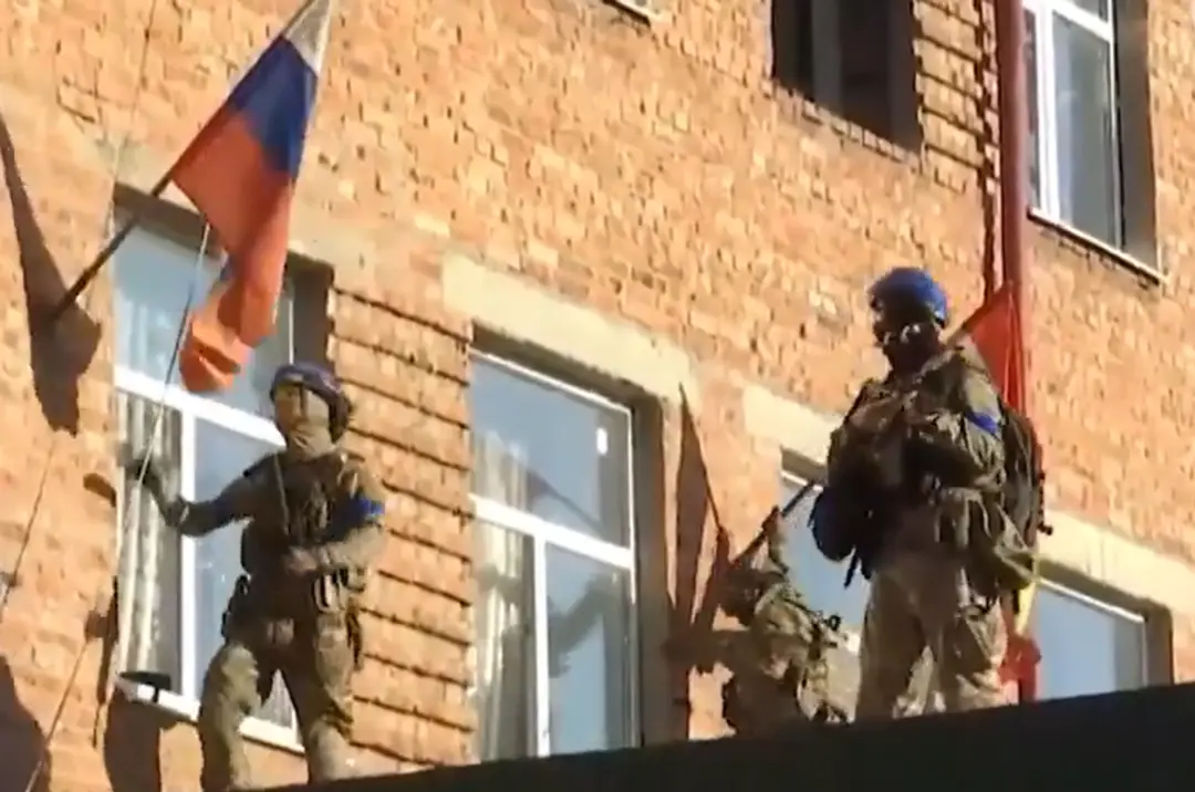 Ukrajinskí vojaci sťahujú ruské zástavy.