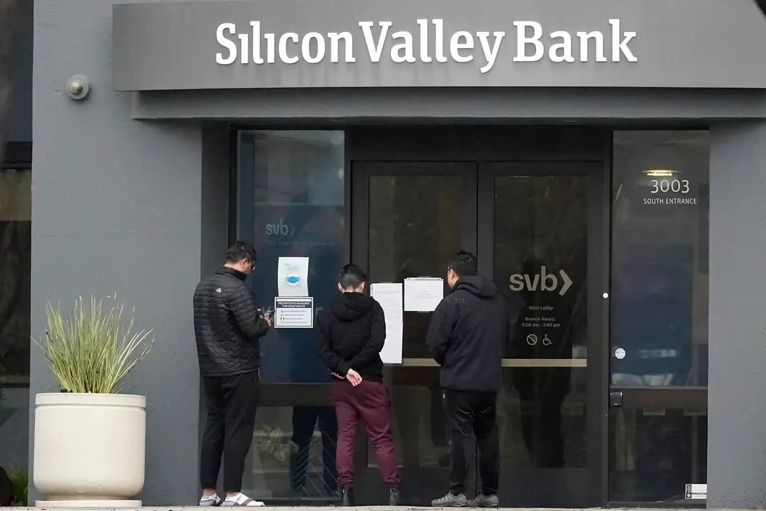 Ľudia si čítajú oznam pred vchodom do banky Silicon Valley Bank