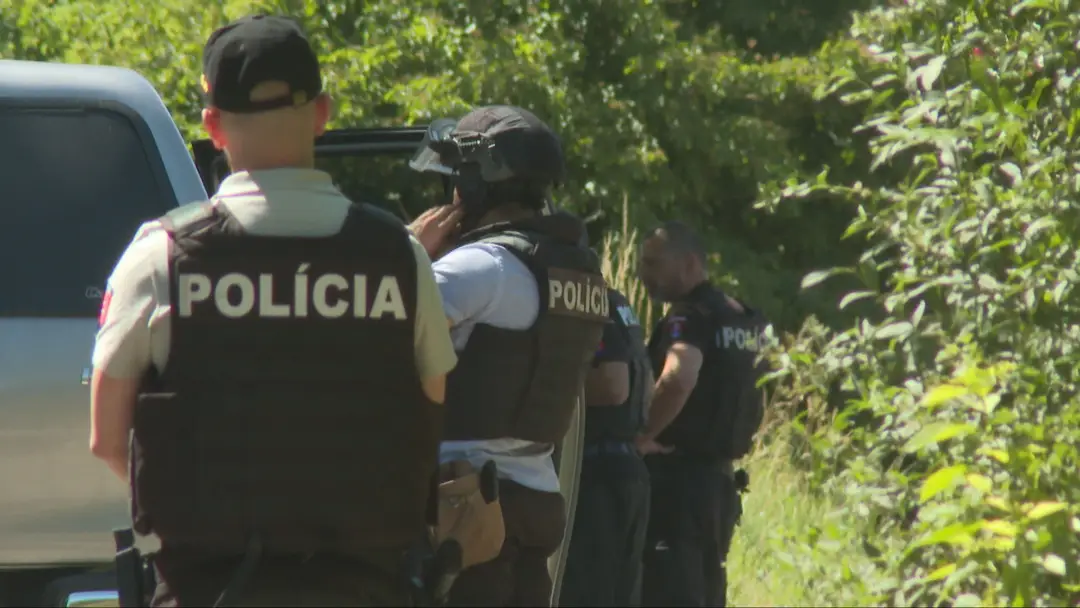 Policajti pri chatke, kde sa muž zamkol.