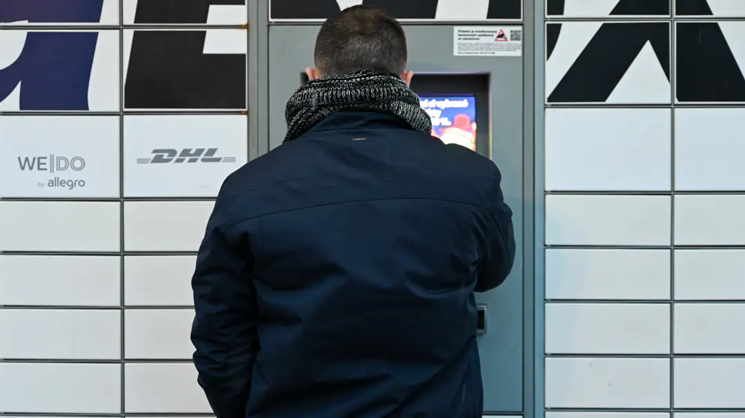 Na snímke je muž, ktorý si vyberá tovar s výdajného boxu. 