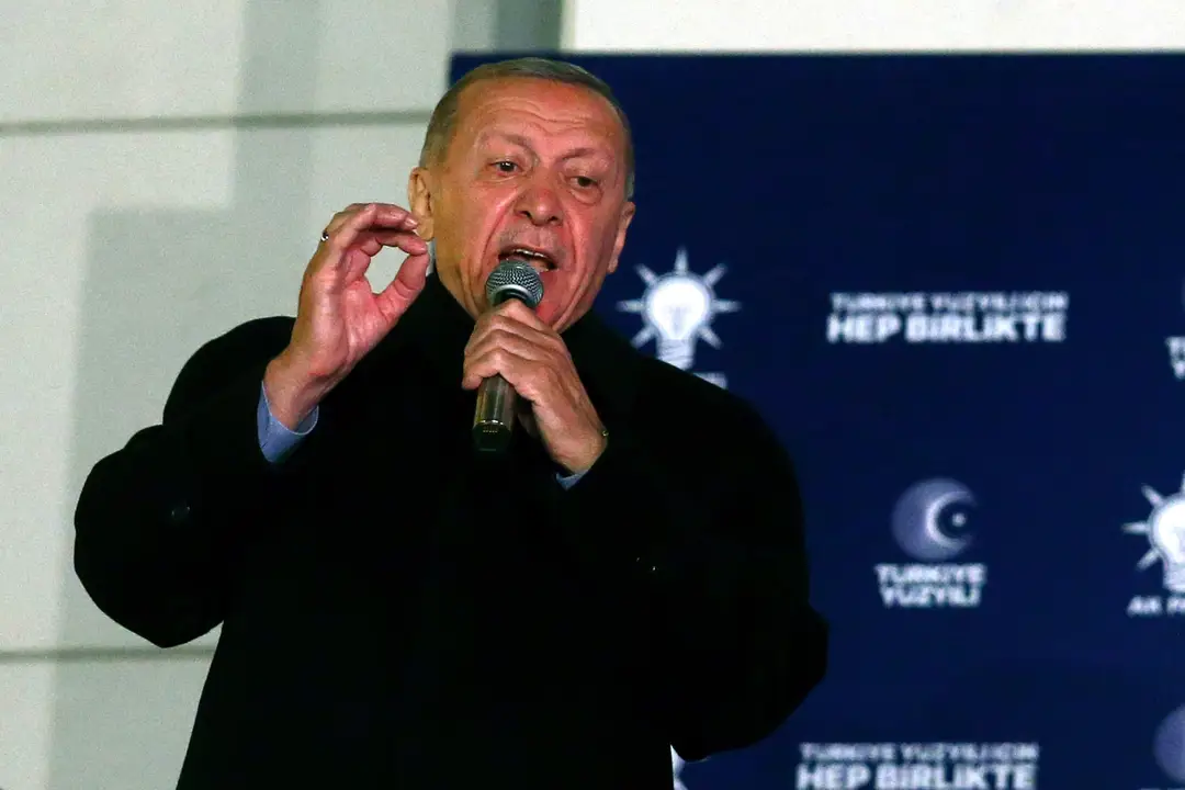 Turecký prezident Recep Tayyip Erdogan s mikrofónom v ruke počas prejavu.
