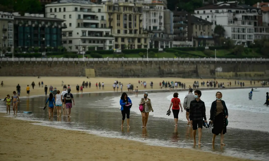 Ľudia kráčajú po pláži po zrušení lockdownu v severošpanielskom meste San Sebastian v nedeľu 9. mája 2021.