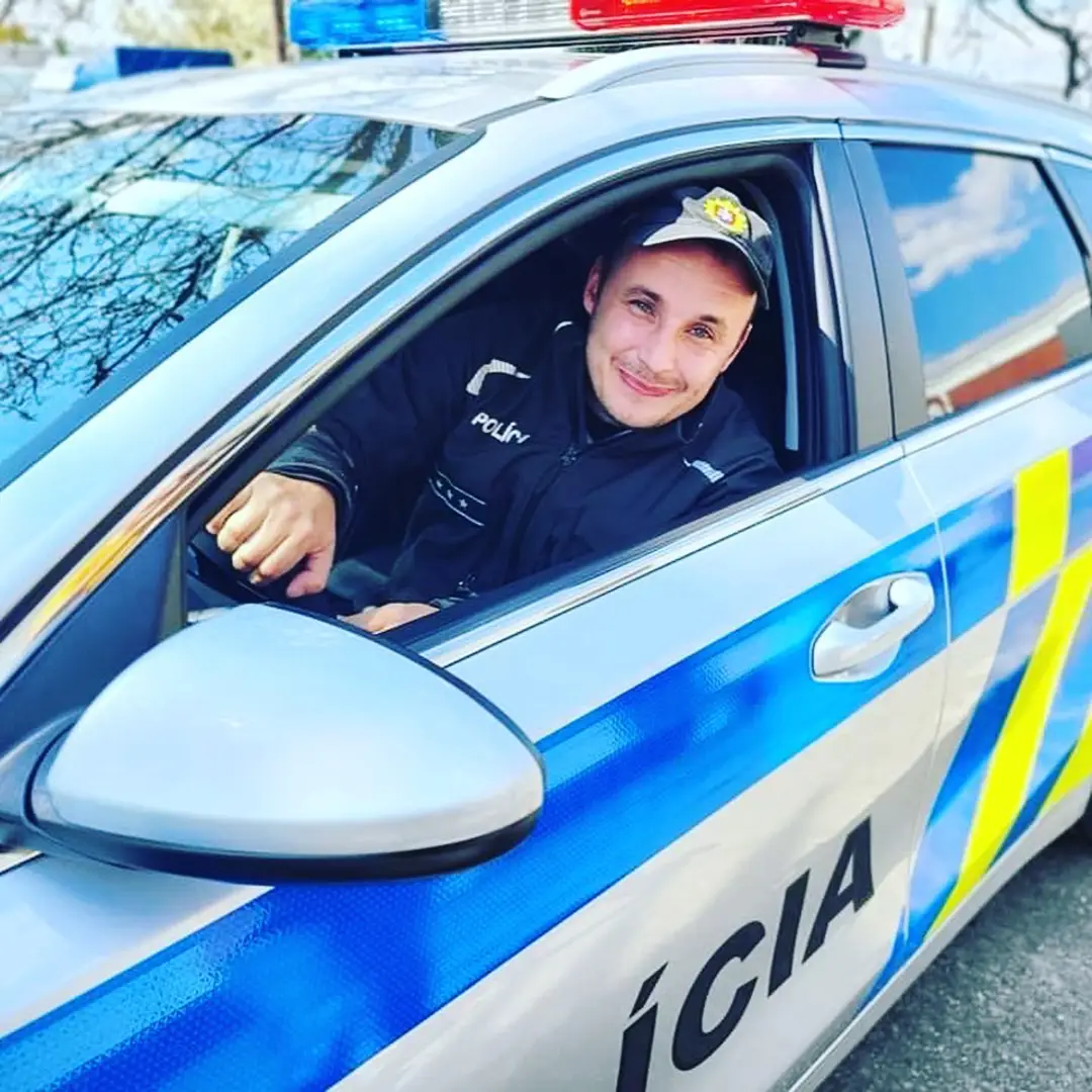 Policajt sedí v novom policajtom aute.