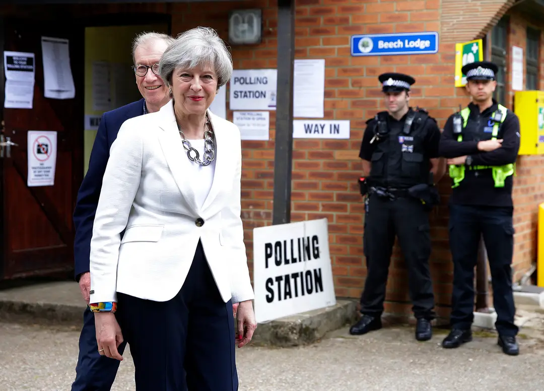 Britská premiérka Theresa Mayová a jej manžel Philip odchádzajú z volebnej miestnosti.