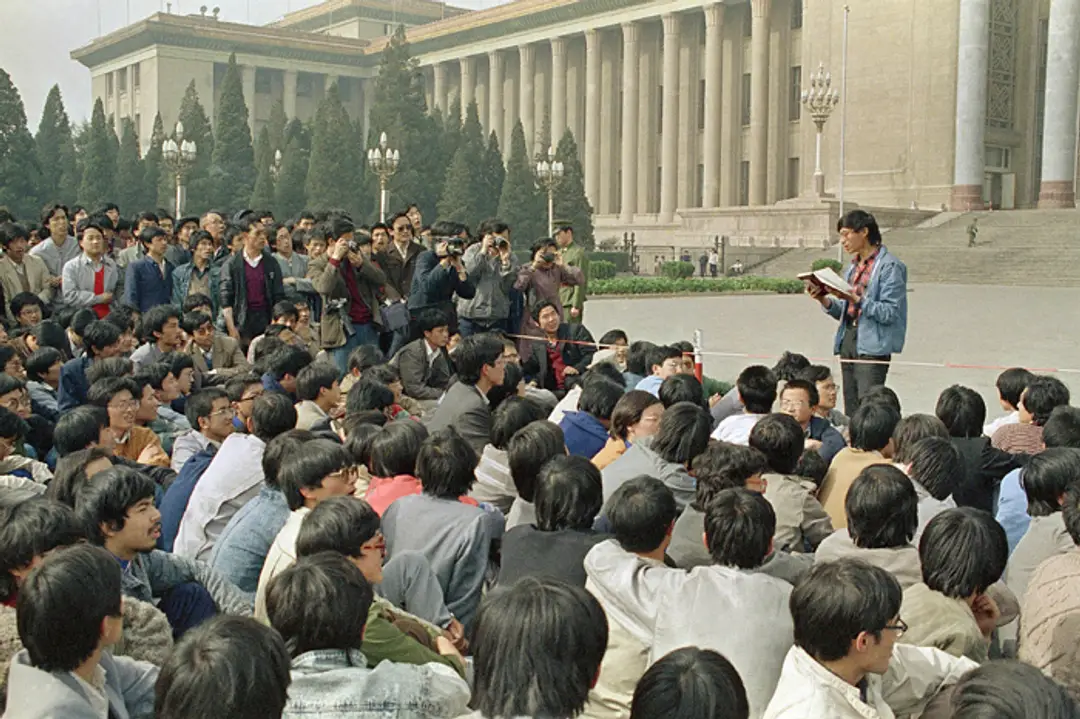 Na snímke z 18. apríla 1989 študentský líder číta zoznam požiadaviek študentom, ktorí sedia pred parlamentom v Pekingu.